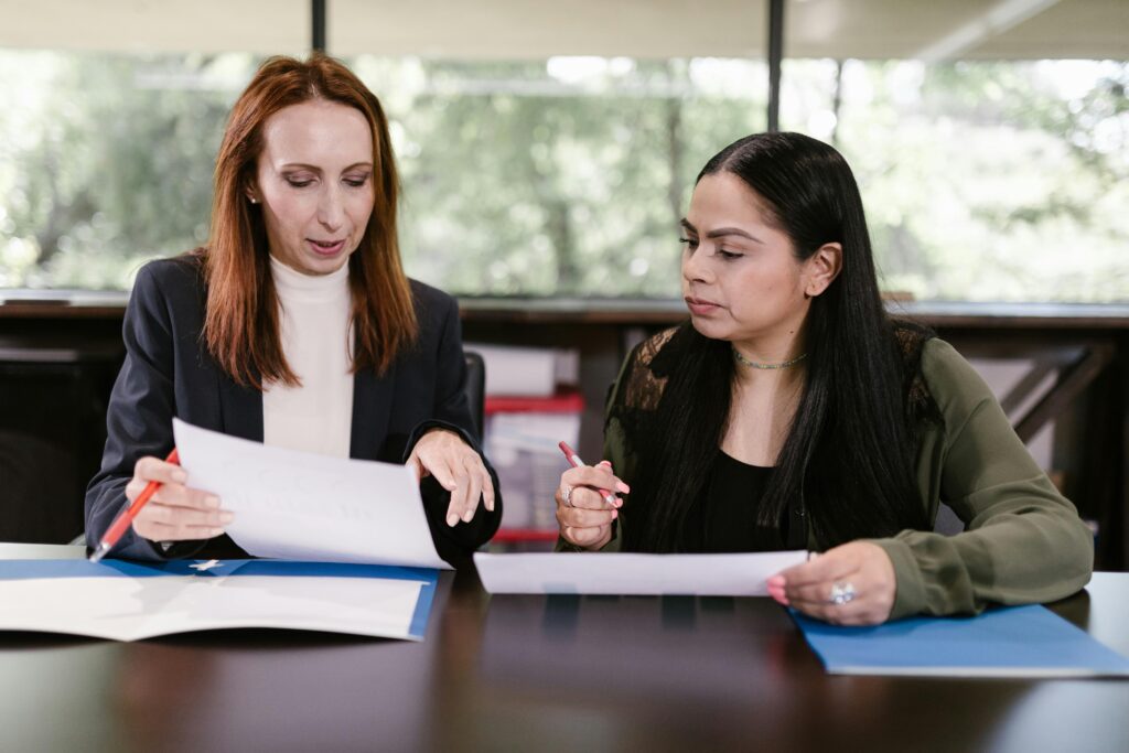 A wedding vendor discussing a contract with a bride in an office setting, highlighting professionalism and budget concerns.